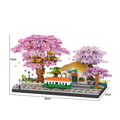 Model of a building with cherry blossom trees and a small house, with measurements on a white background.