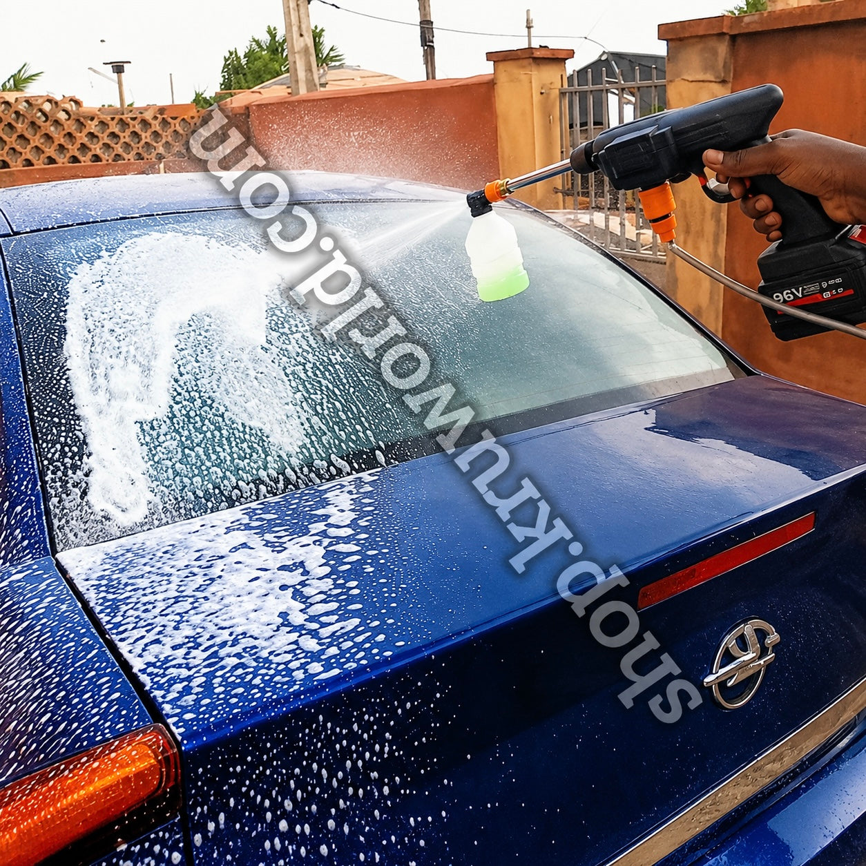 Load video: portable cordless car wash gun spraying foam on a blue car during an outdoor car cleaning demonstration.