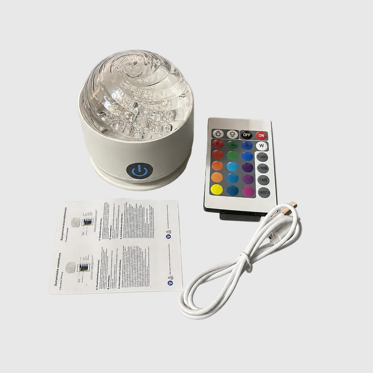spiral design Color-changing LED light with remote control, power cord, and user manual on a white background