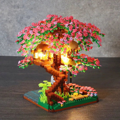 mini sakura treehouse with pink flowers and lights on a wooden surface