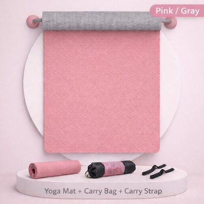 Pink yoga mat with gray top, black carry bag, and straps on a white background