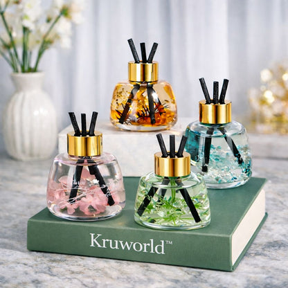 Four reed diffuser bottles with gold caps on a green book, featuring the brand 'Kruworld'.