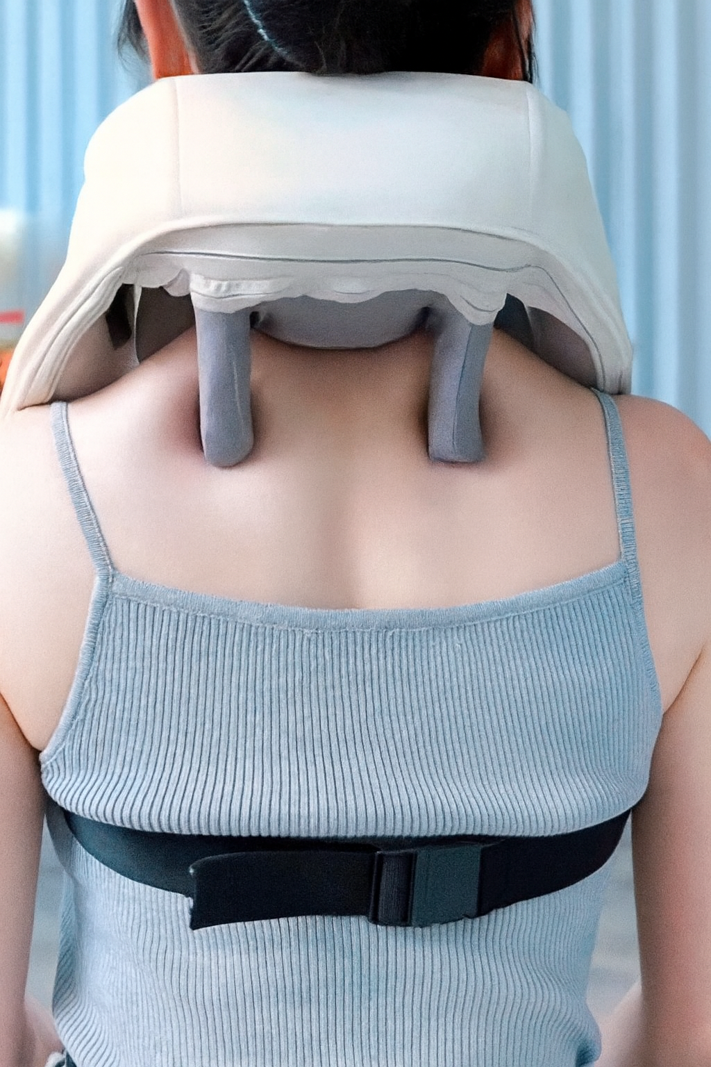 Person using a neck and shoulder massager with a blurred background