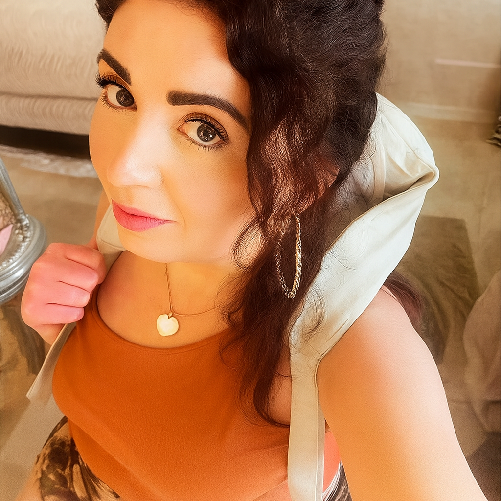 Woman with a beige headscarf and orange top in an indoor setting