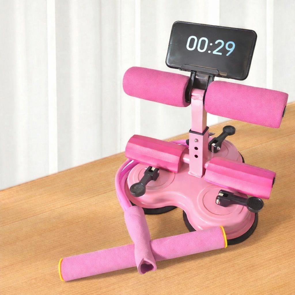 Pink assistive sit-up device with digital timer on a wooden surface